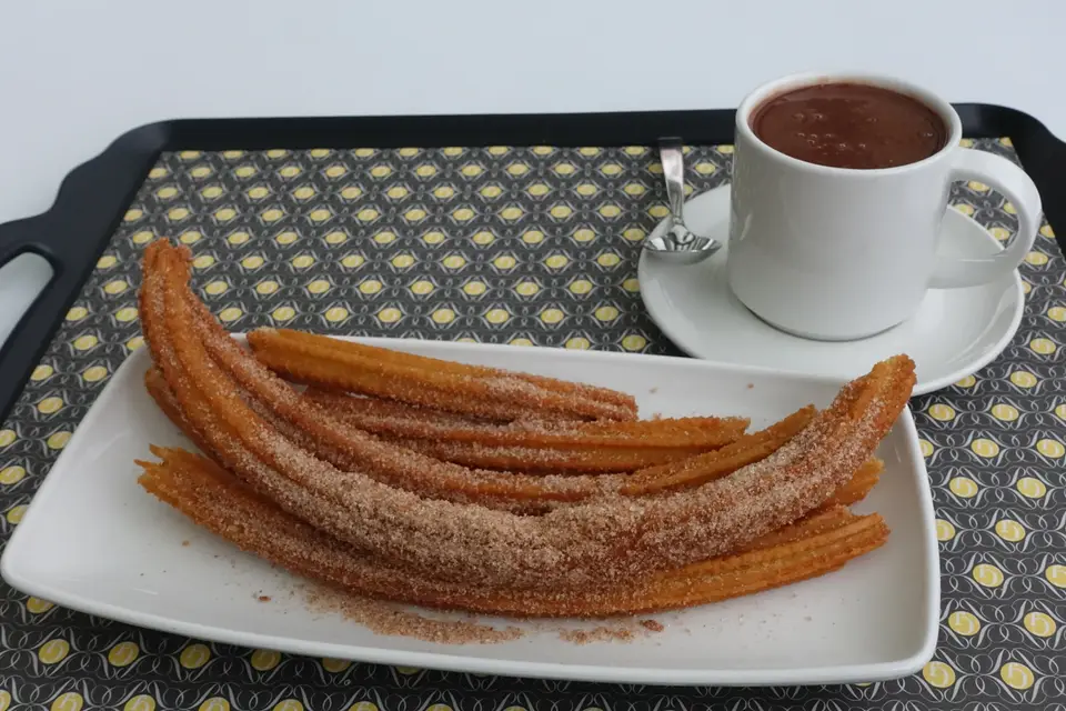 Churros saupoudrés de sucre et leur chocolat chaud