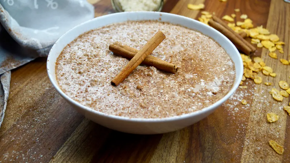 Riz au lait crémeux saupoudré de cannelle, bâtons de cannelle posés dessus