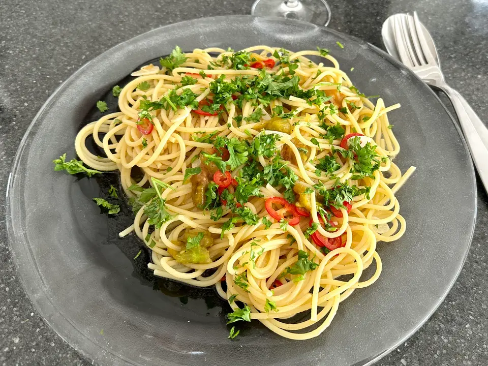 Spaghetti à l'ail et à l'huile d'olive, persil et flocons de piment, dans une assiette de verre