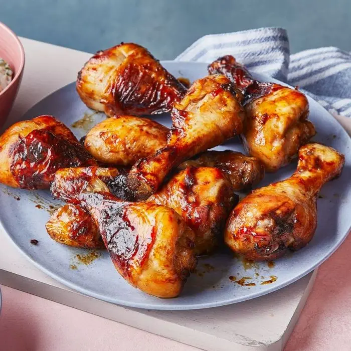 Pilons de poulet laqués et caramélisés sur une assiette bleue