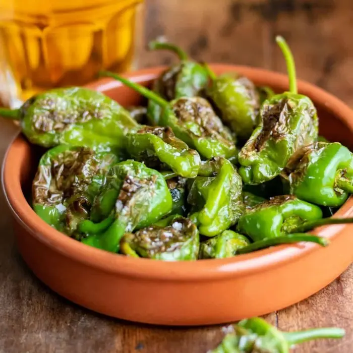 Petits piments verts de Padrón grillés dans une cassole en terre cuite
