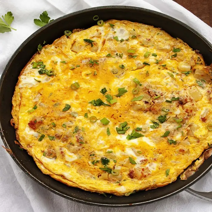 Omelette dorée garnie de chorizo et de pommes de terre, dans sa poêle