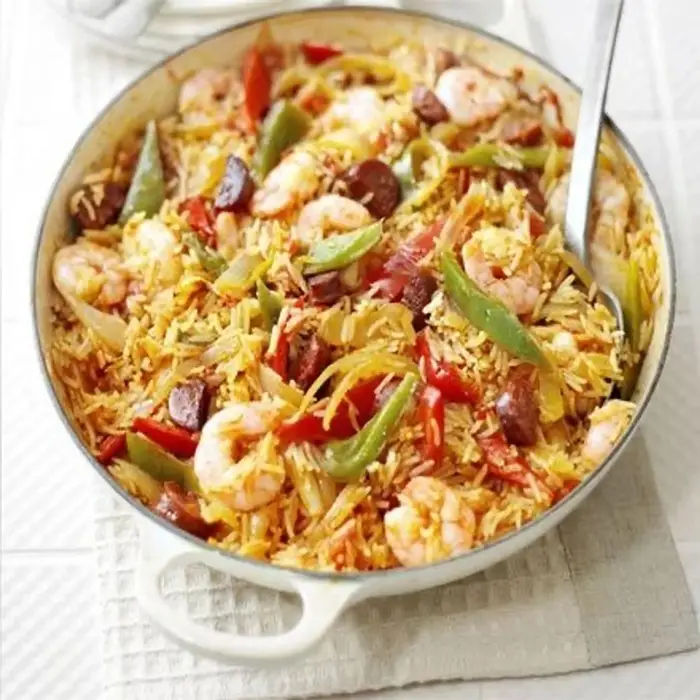 Riz aux crevettes, poivrons et chorizo dans un plat en fonte