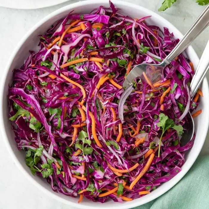 Salade de chou rouge et de carottes émincés dans un saladier blanc