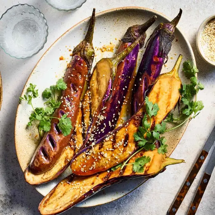 Aubergines grillées nappées de sauce au yaourt et couvertes d'herbes