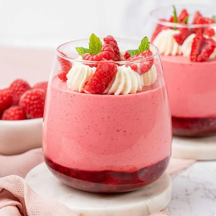 Mousse rose à la framboise en verrines, framboises et menthe sur le dessus