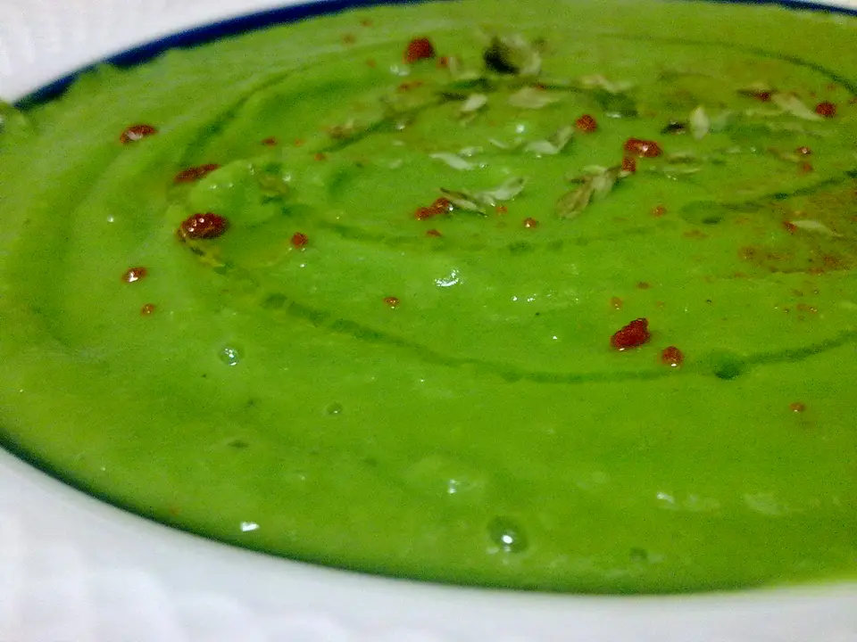 Velouté de petits pois vert vif dans une assiette creuse